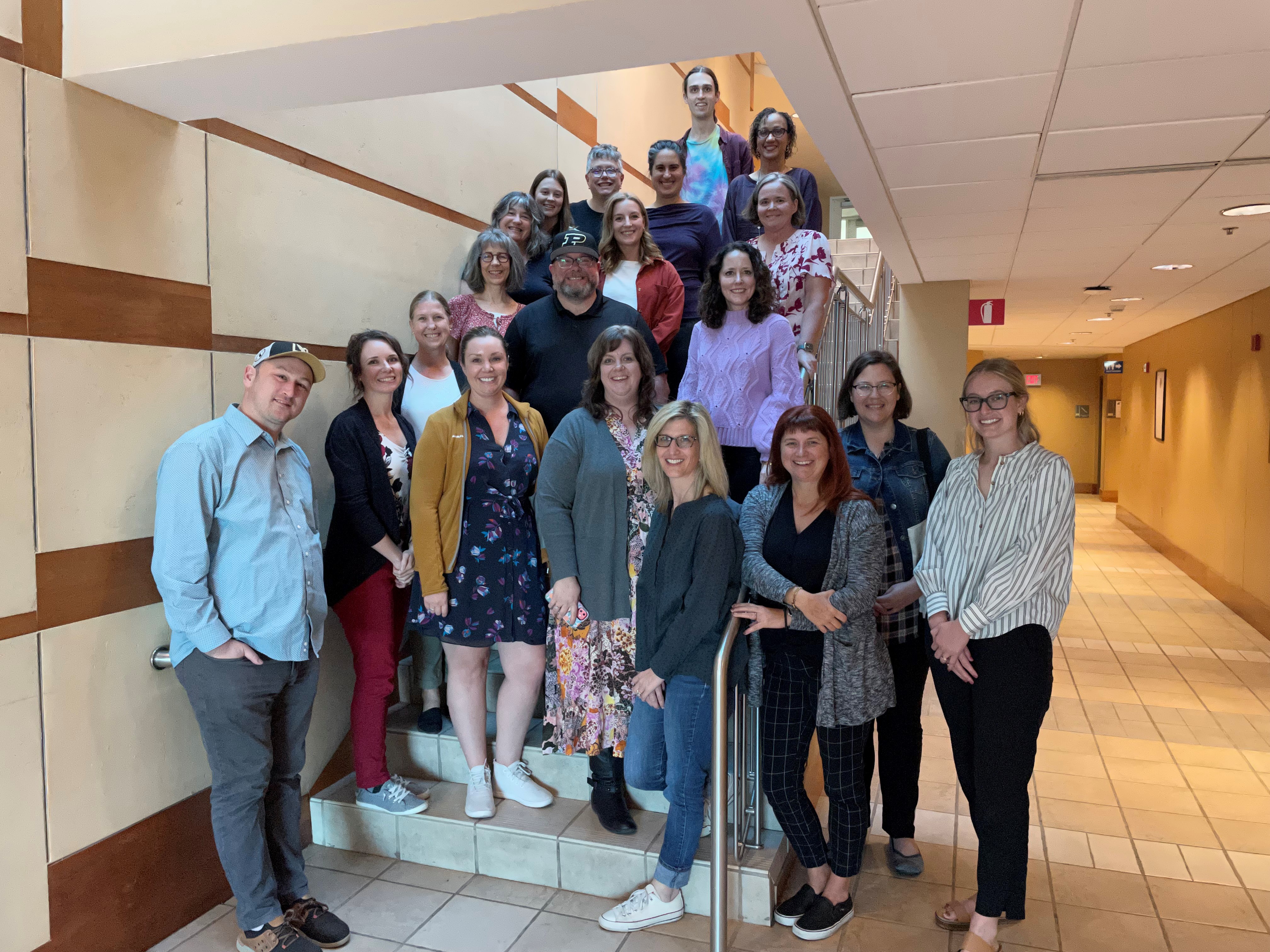 Individuals pose on stairs at the 2022 Montessori Research Retreat.